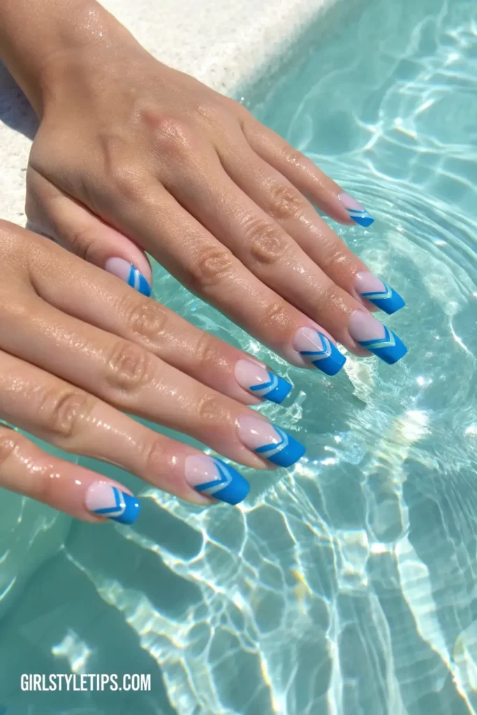 Wavy blue French tip vacation nails inspired by ocean colors for summer beach trips